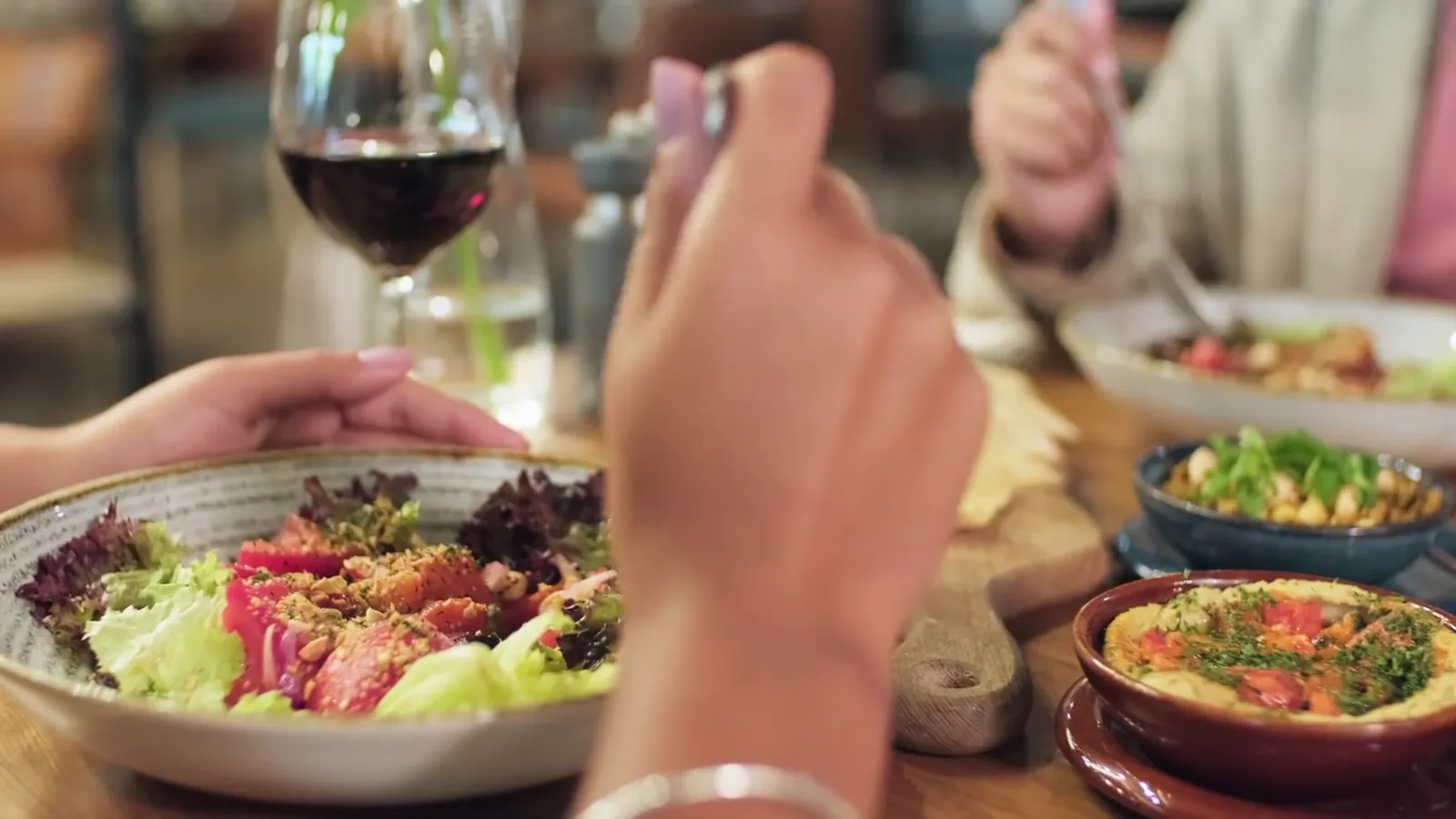 Stockaufnahme: Menschen essen gemeinsam an einem gedeckten Tisch